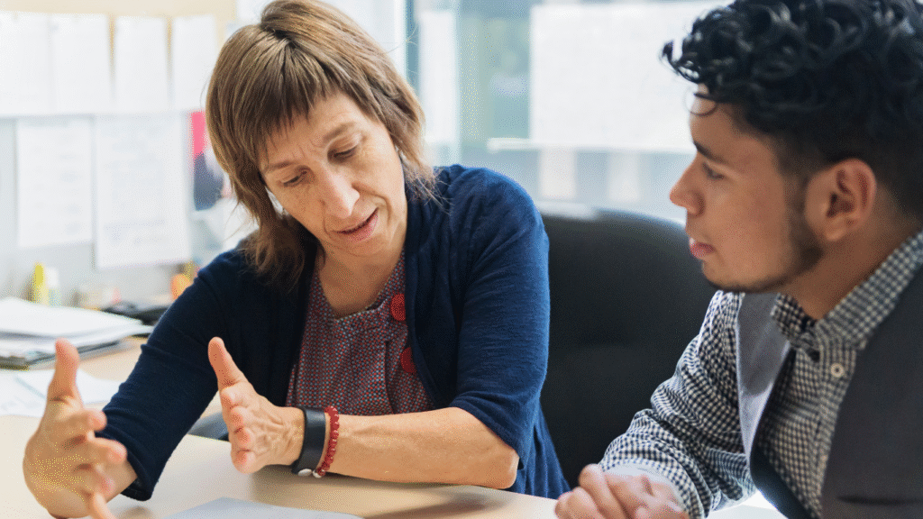 A mentor guiding a young person through barriers to employment.