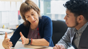 A mentor guiding a young person through barriers to employment.