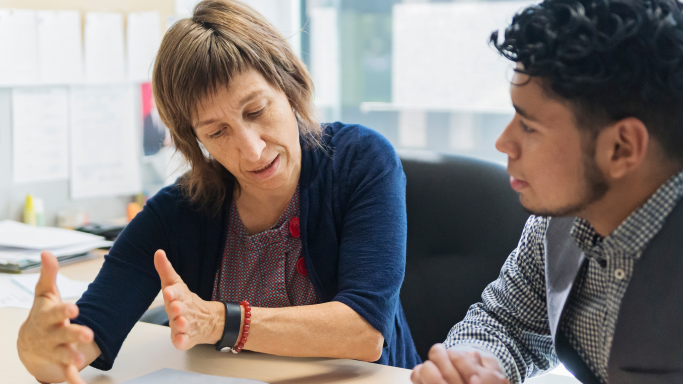 A mentor guiding a young person through barriers to employment.