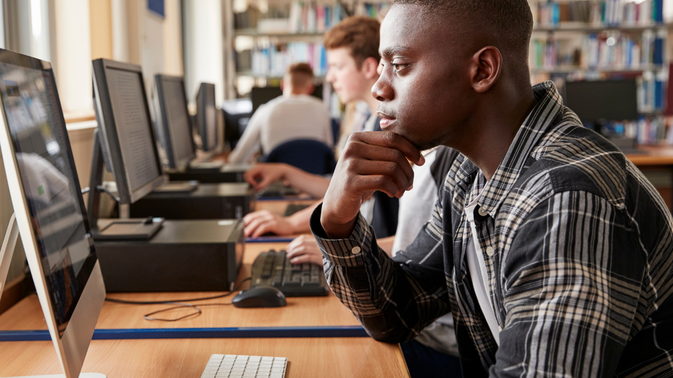 A young man studying AI on a computer.